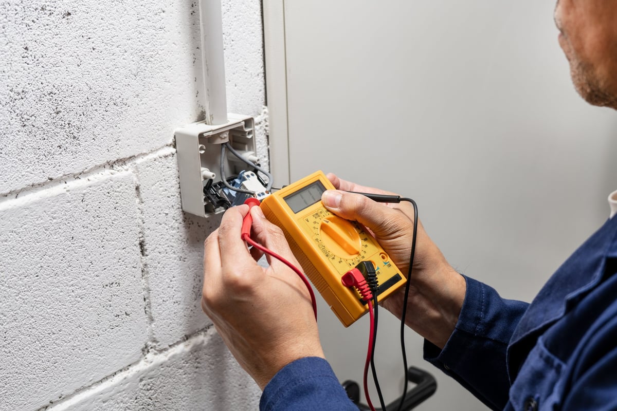 Elektricien controleert een stopcontact en schakelaar